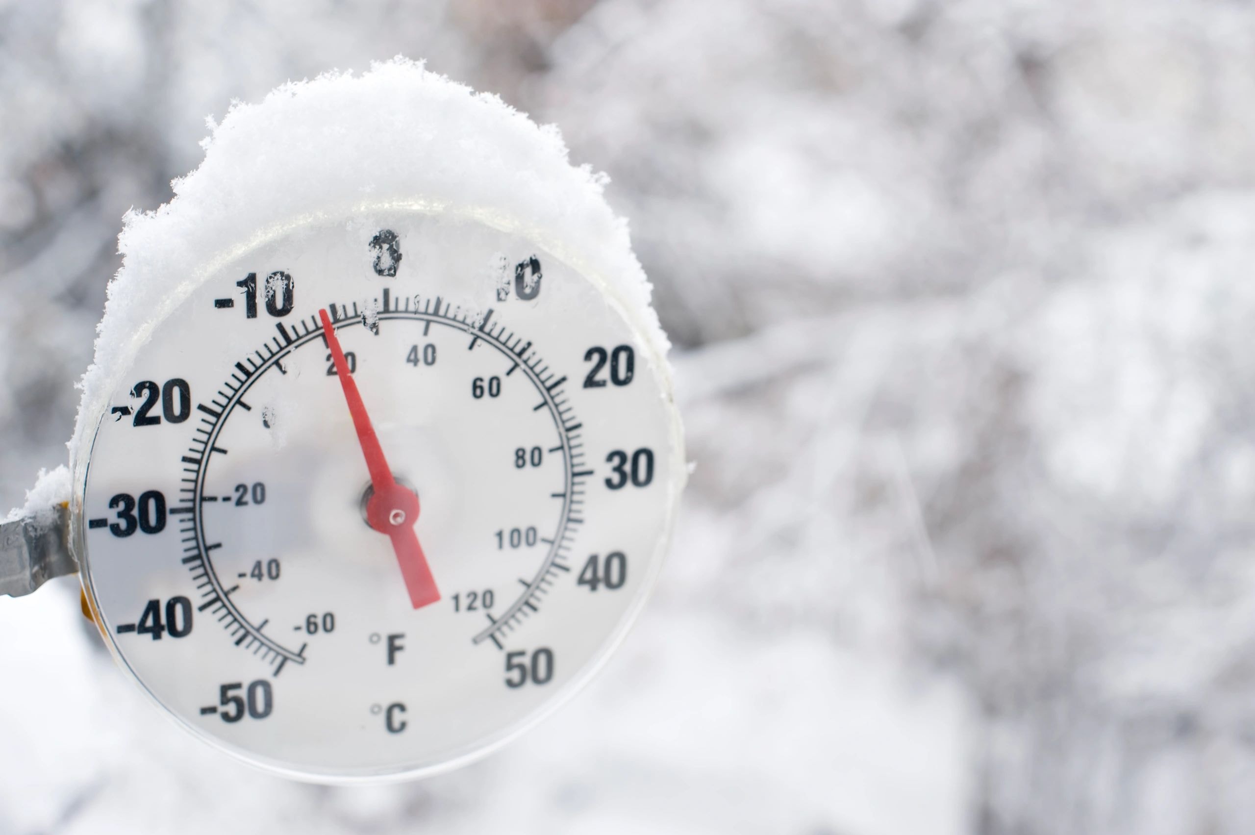 Frost-covered thermometer in extreme cold winter conditions